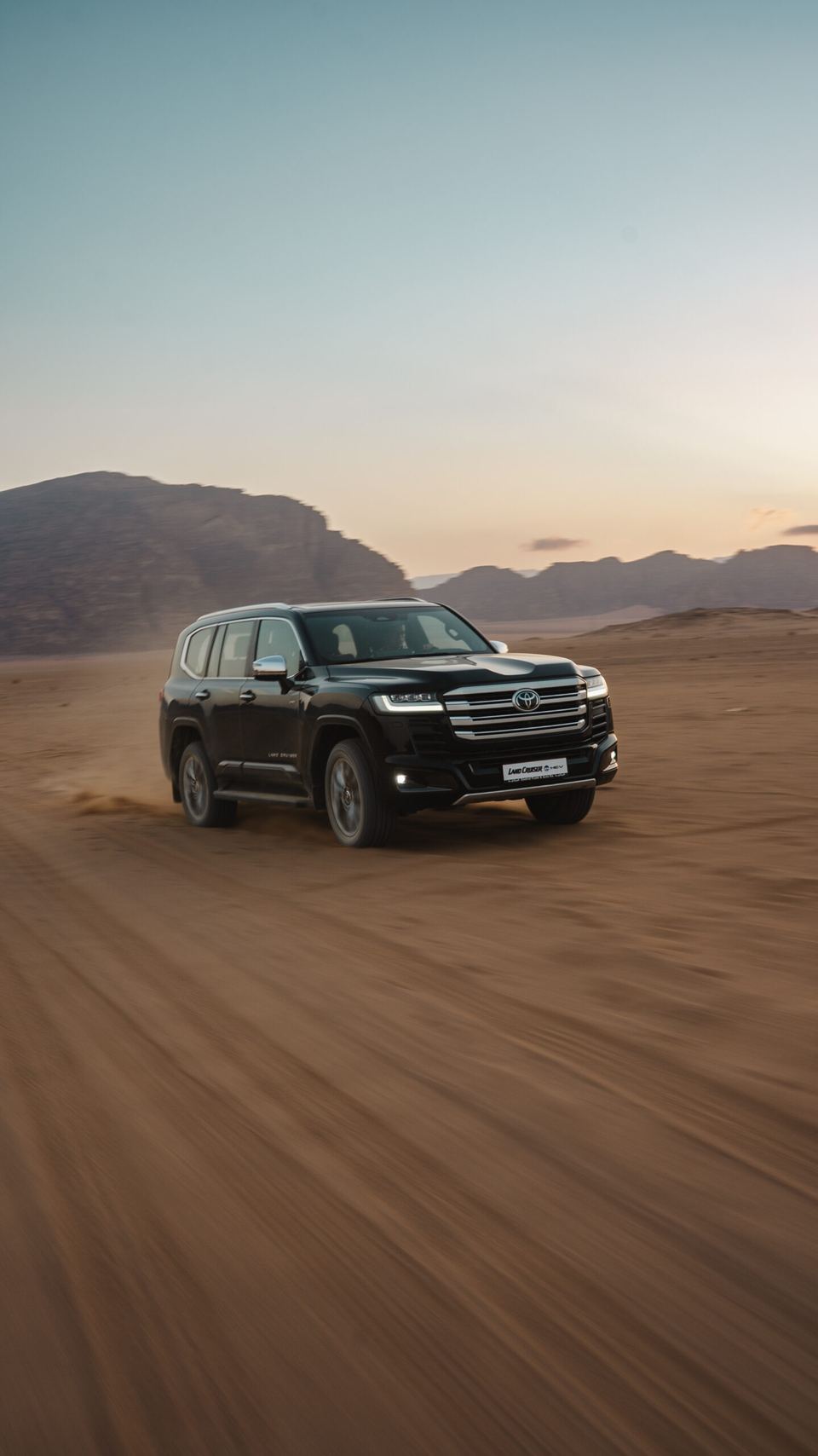 Toyota Land Cruiser 300 HEV driving through Wadi Rum at golden hour