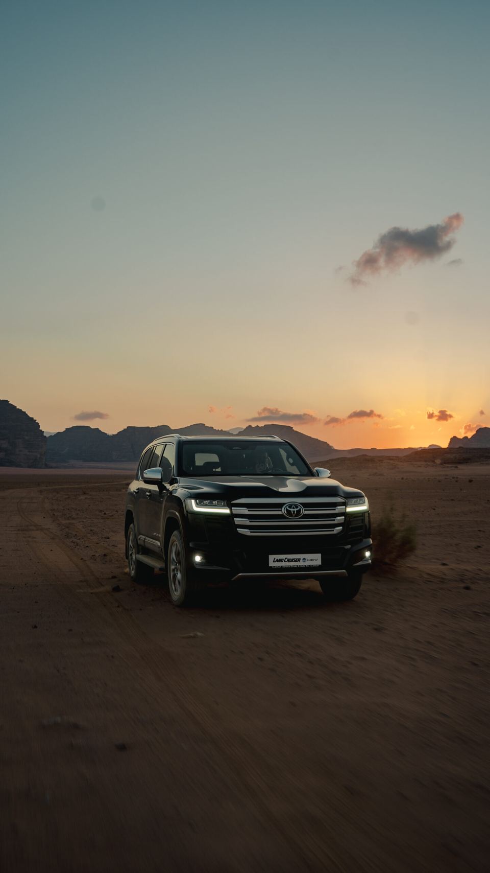 Toyota Land Cruiser 300 HEV silhouetted against a Wadi Rum sunset