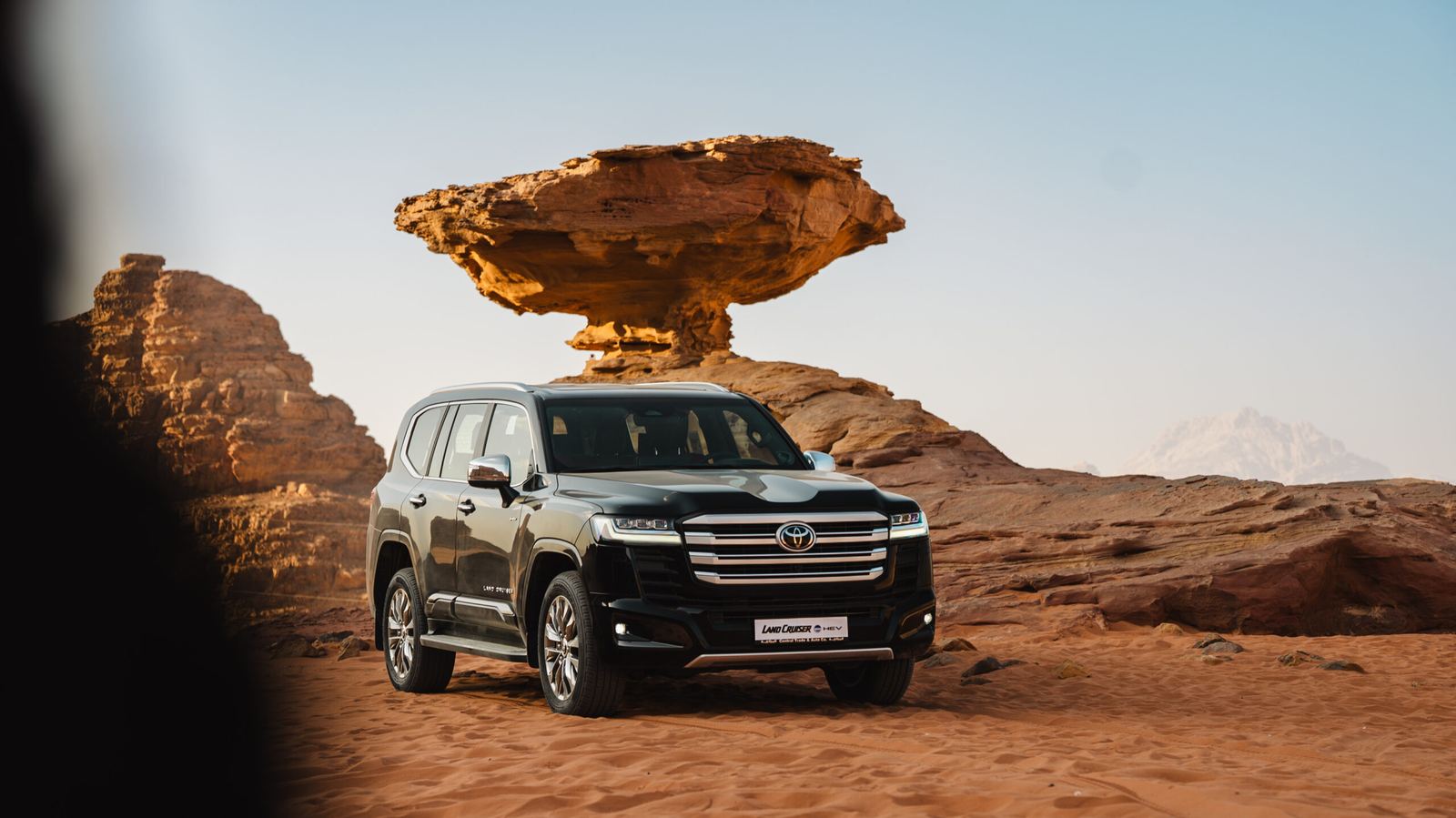 Toyota Land Cruiser 300 HEV parked beneath the mushroom rock in Wadi Rum