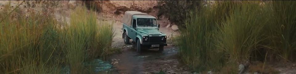 Land Rover Defender crossing a green riverbed in Jordan